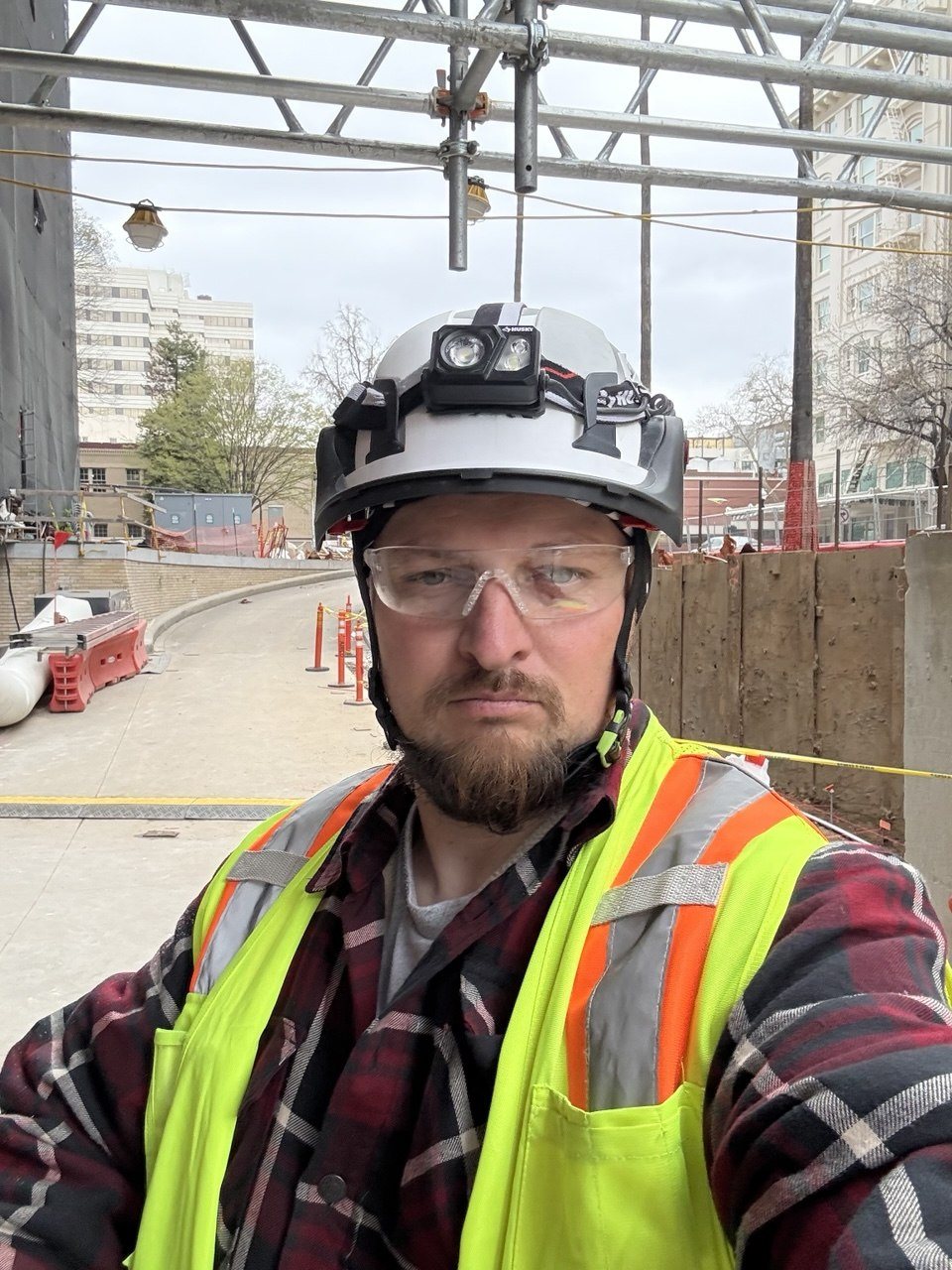 Val, owner of RNDLine Construction, on a job site in a hard hat and safety vest