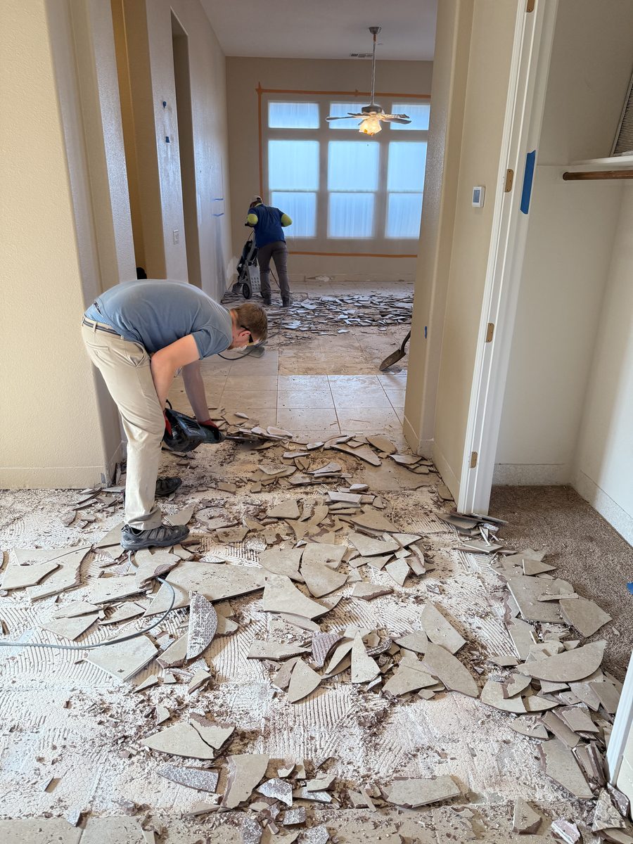 Crew removing old tile flooring during demolition
