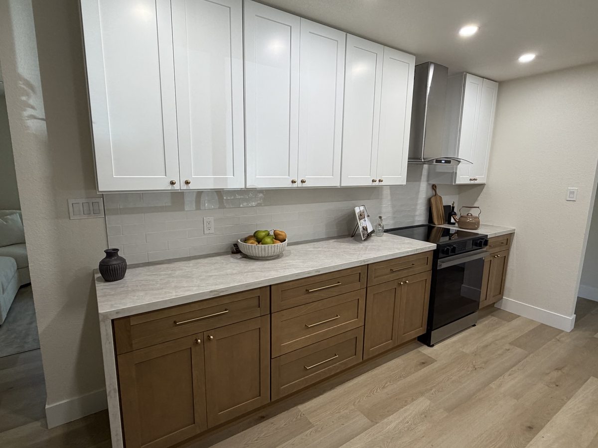 Kitchen remodel with white uppers, wood lowers and a vented hood