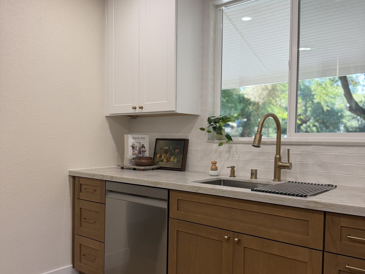 Kitchen sink run with brass faucet and tile backsplash