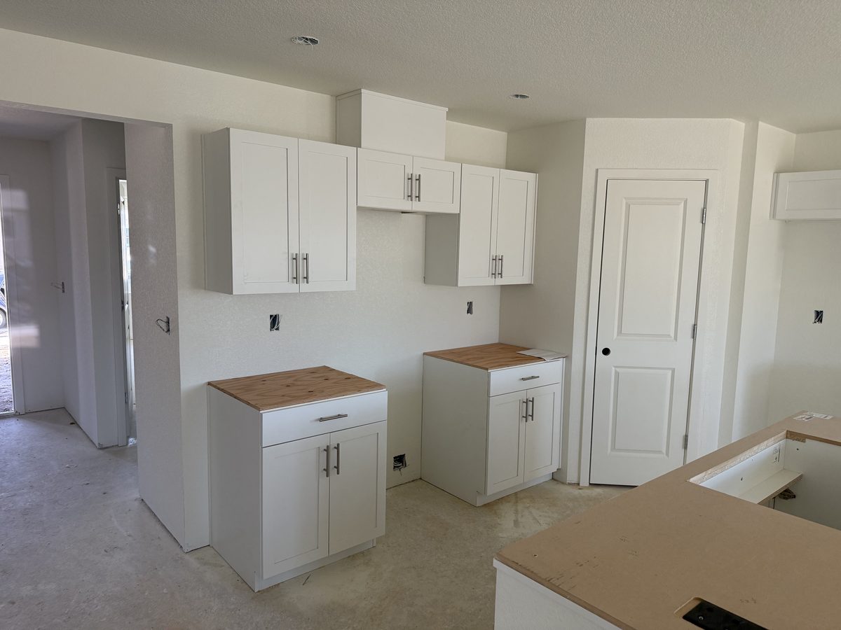 Kitchen cabinetry being set during a remodel in progress